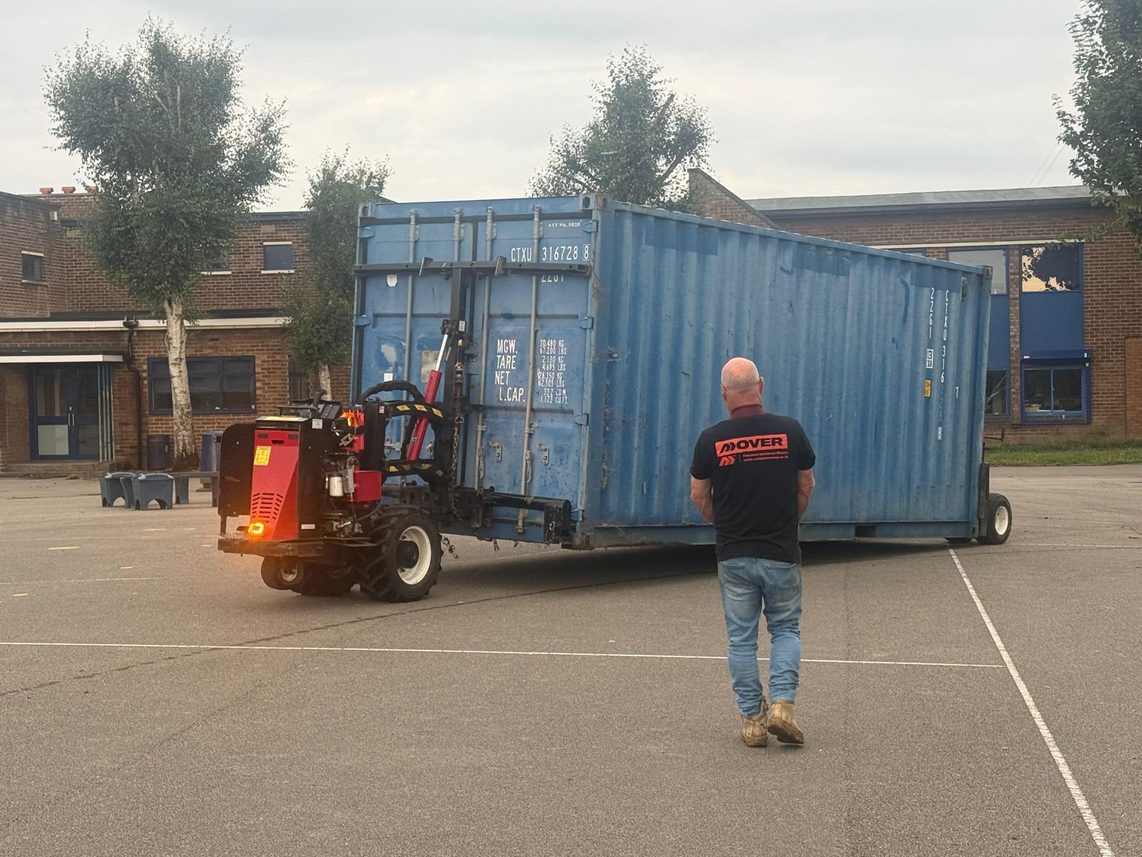 Blue shipping container standing on a paved site