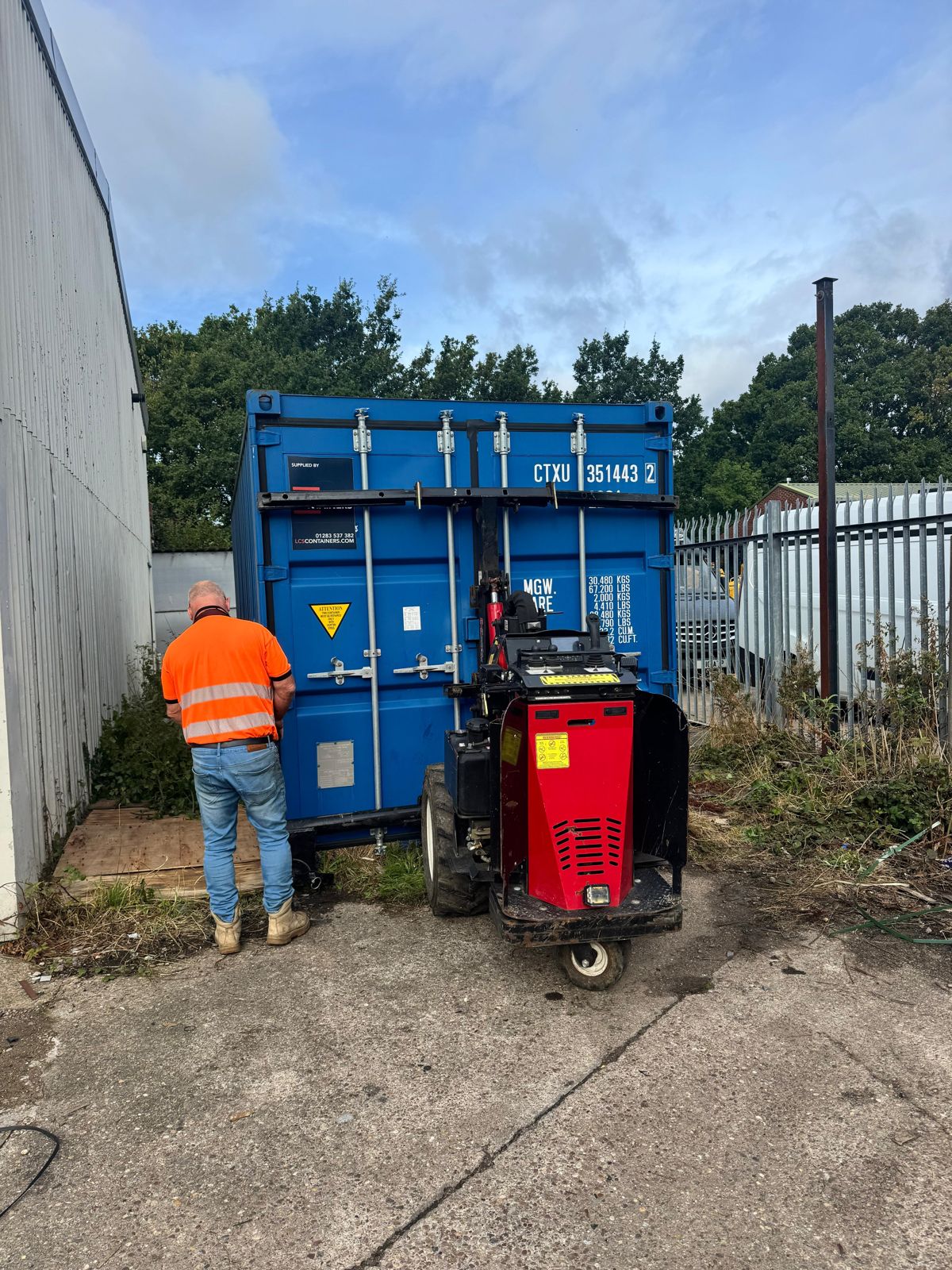 Blue shipping container positioned between two buildings
