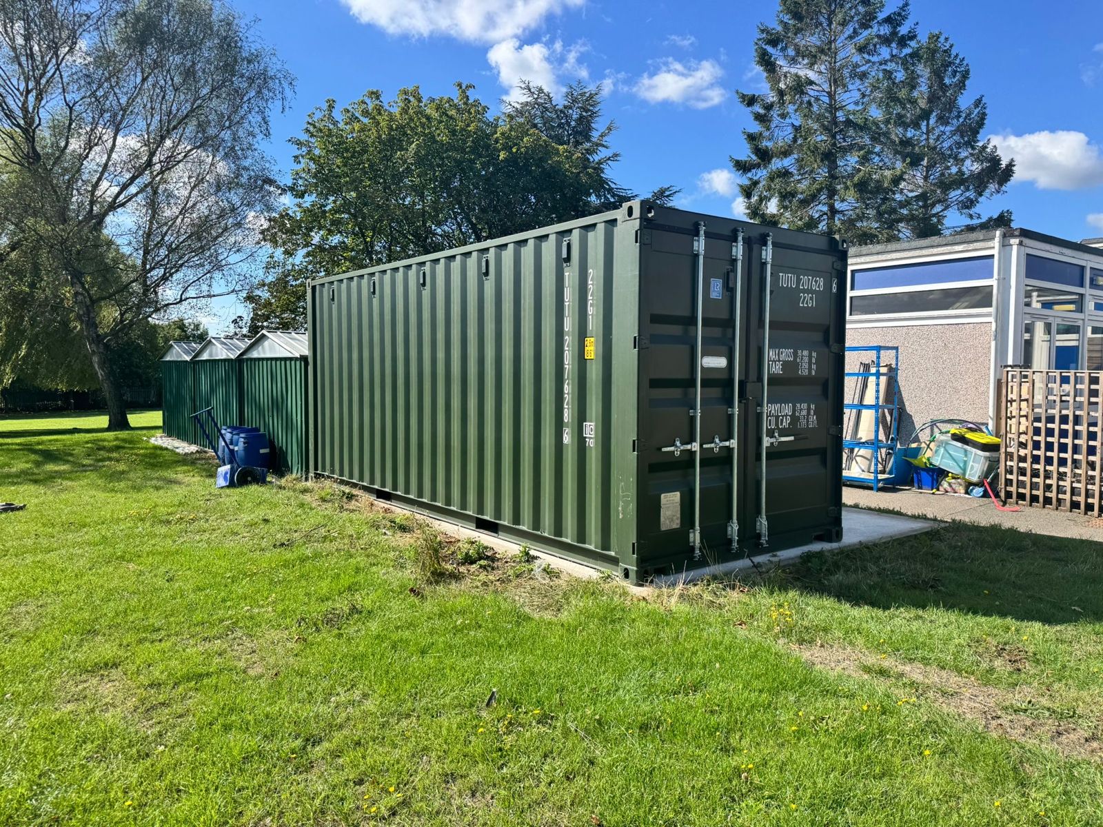 Green shipping container standing on grass
